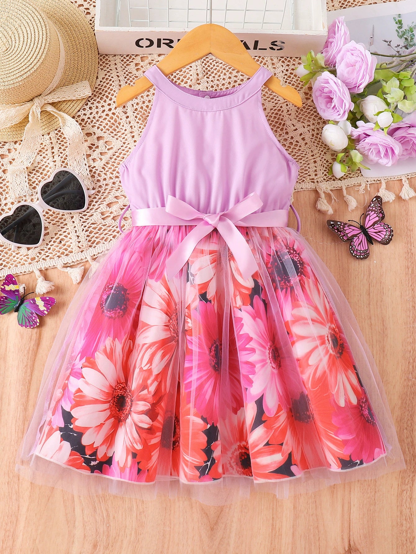 Floral print toddler dress with halter neck, pink sash, and tulle overlay.