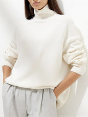 Ivory relaxed turtleneck sweater with sculptural sleeves and ribbed cuffs.