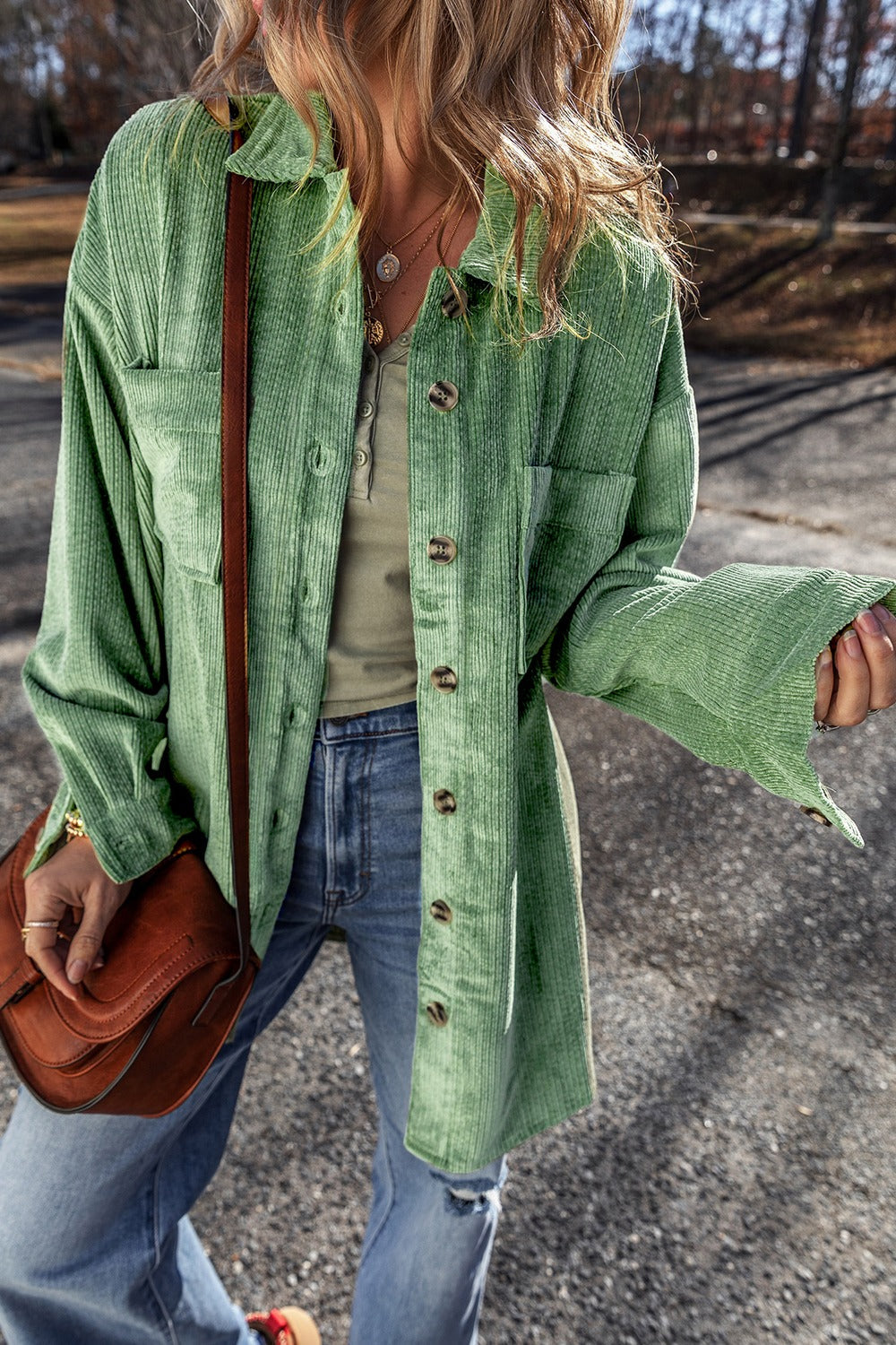 Green corduroy overshirt with button cuffs and chest pockets, styled open over a henley.