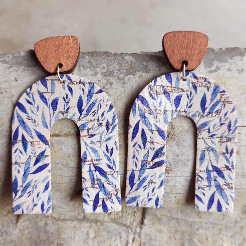 Archway cork statement earrings with blue leaf pattern and wooden top.