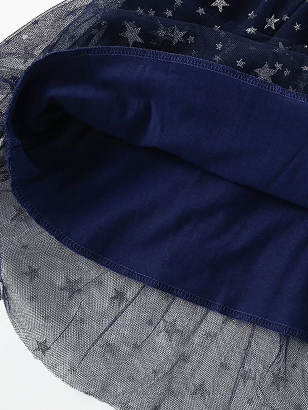 Navy baby dress with star print tulle overlay and cotton lining.