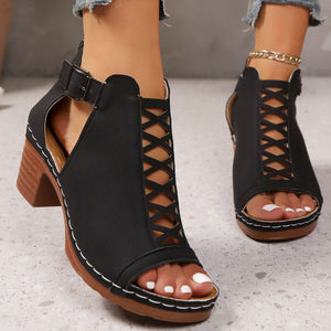 Black criss-cross cut-out block heel sandals with ankle strap and buckle detail.