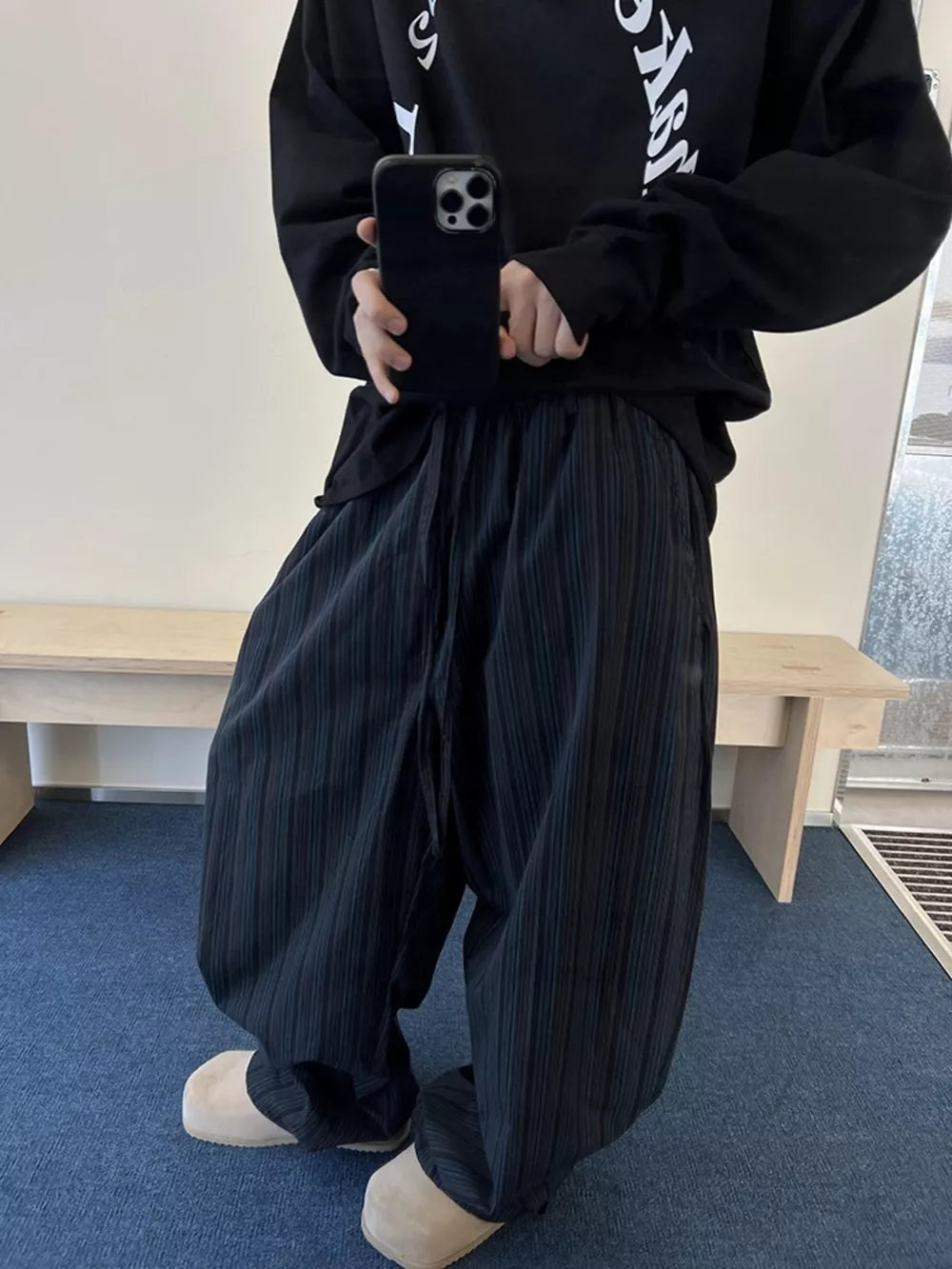 Black pinstripe wide-leg sweatpants with drawstring and pockets.