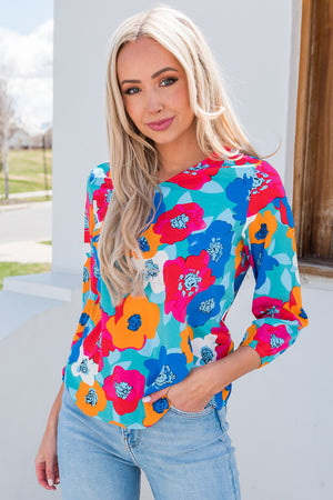 Painterly floral print blouse with V-neck and 3/4 sleeves in turquoise and hot pink.