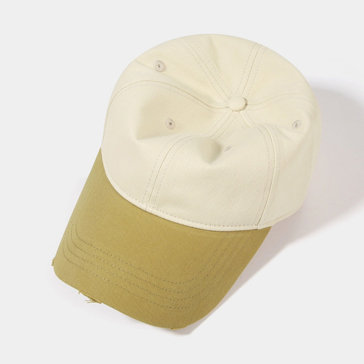 Distressed two-tone baseball cap in cream and olive green cotton with a curved brim.