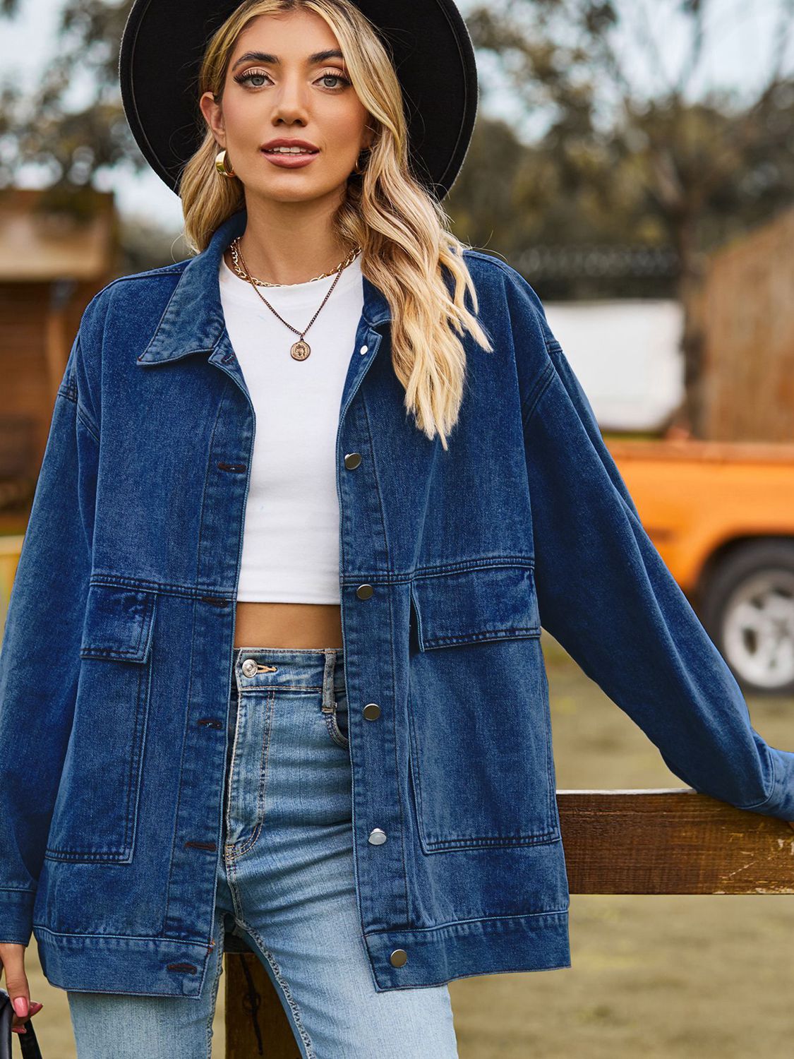 Oversized denim trucker jacket in medium wash with collared neck and chest pockets.
