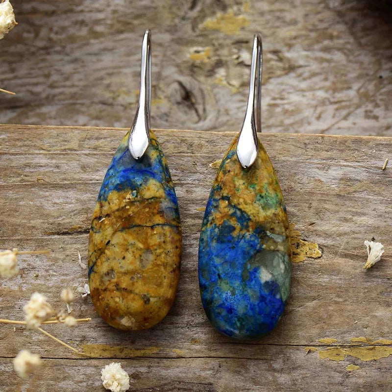Marbled teardrop gemstone earrings in blue, brown, and gold with silver hooks.