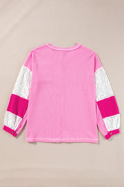 Fuchsia pink waffle knit top with white lace and pink paneled sleeves.