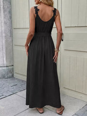 Black lace-trimmed maxi gown with V-neck, sleeveless, and belted waist.