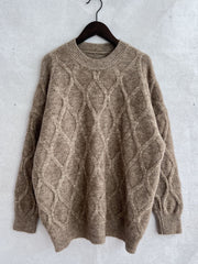 Beige relaxed fit sweater with diamond cable knit texture and crew neck.