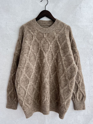 Beige relaxed fit sweater with diamond cable knit texture and crew neck.