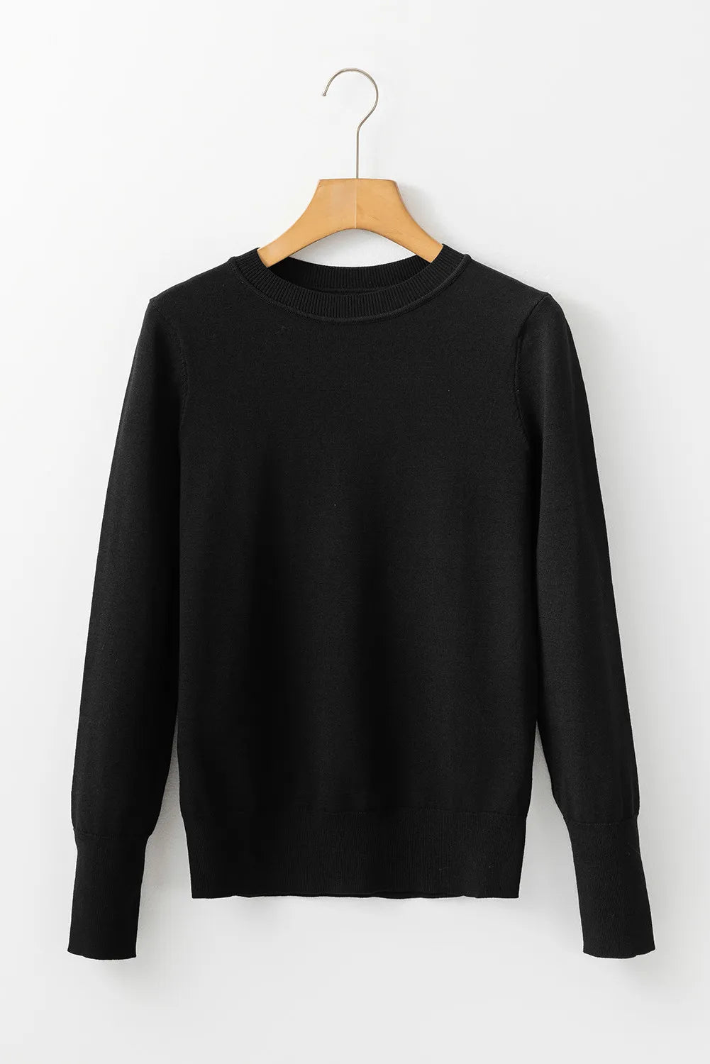 Black crewneck long sleeve knit sweater with ribbed cuffs and hem