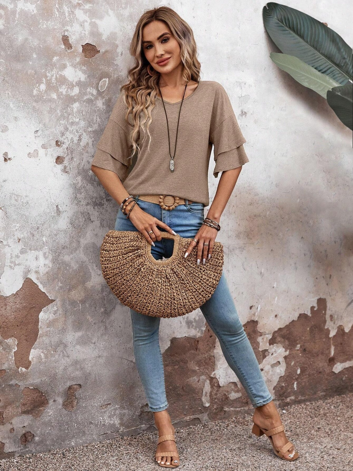 Tiered sleeve jersey tee in mocha with a v-neck, styled with jeans and a straw bag.