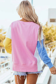 Colorblock sweatshirt in blush pink, white, yellow, and blue with a split hem and ribbed cuffs.