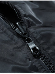 Black bomber jacket detail showing a close-up of the zipper and shiny fabric.