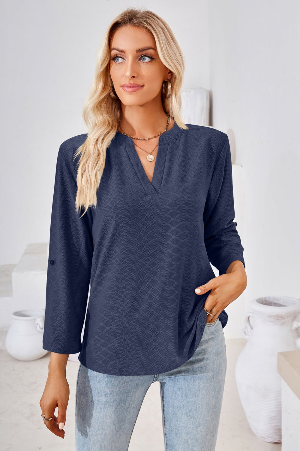 Dark blue textured henley blouse with v-neck and rolled sleeves