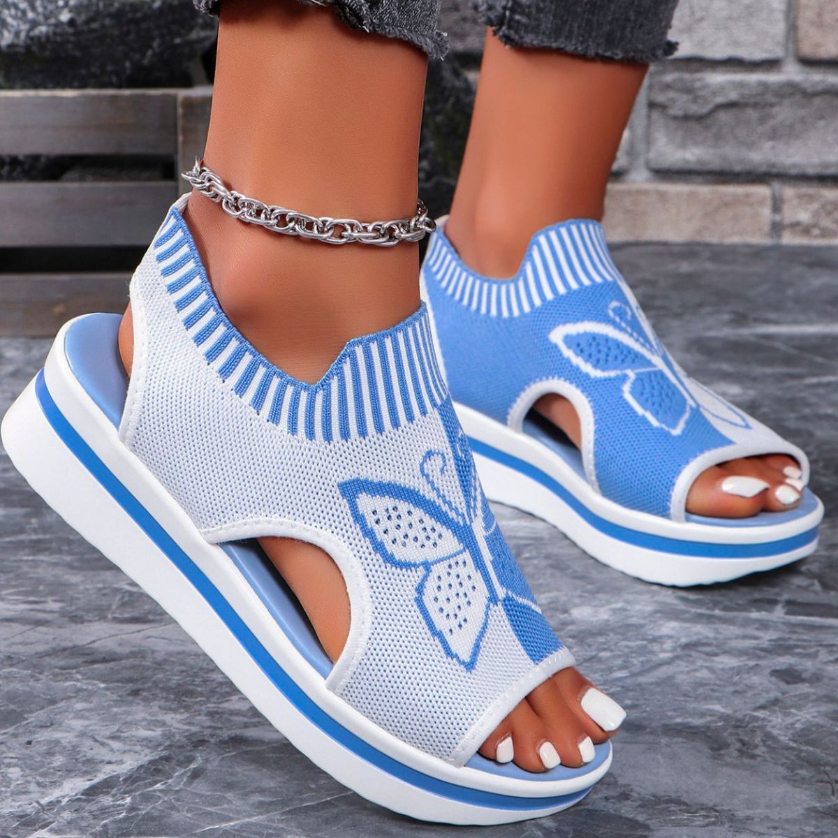 Blue and white open-toe wedge sandals with butterfly motif and mesh detail.