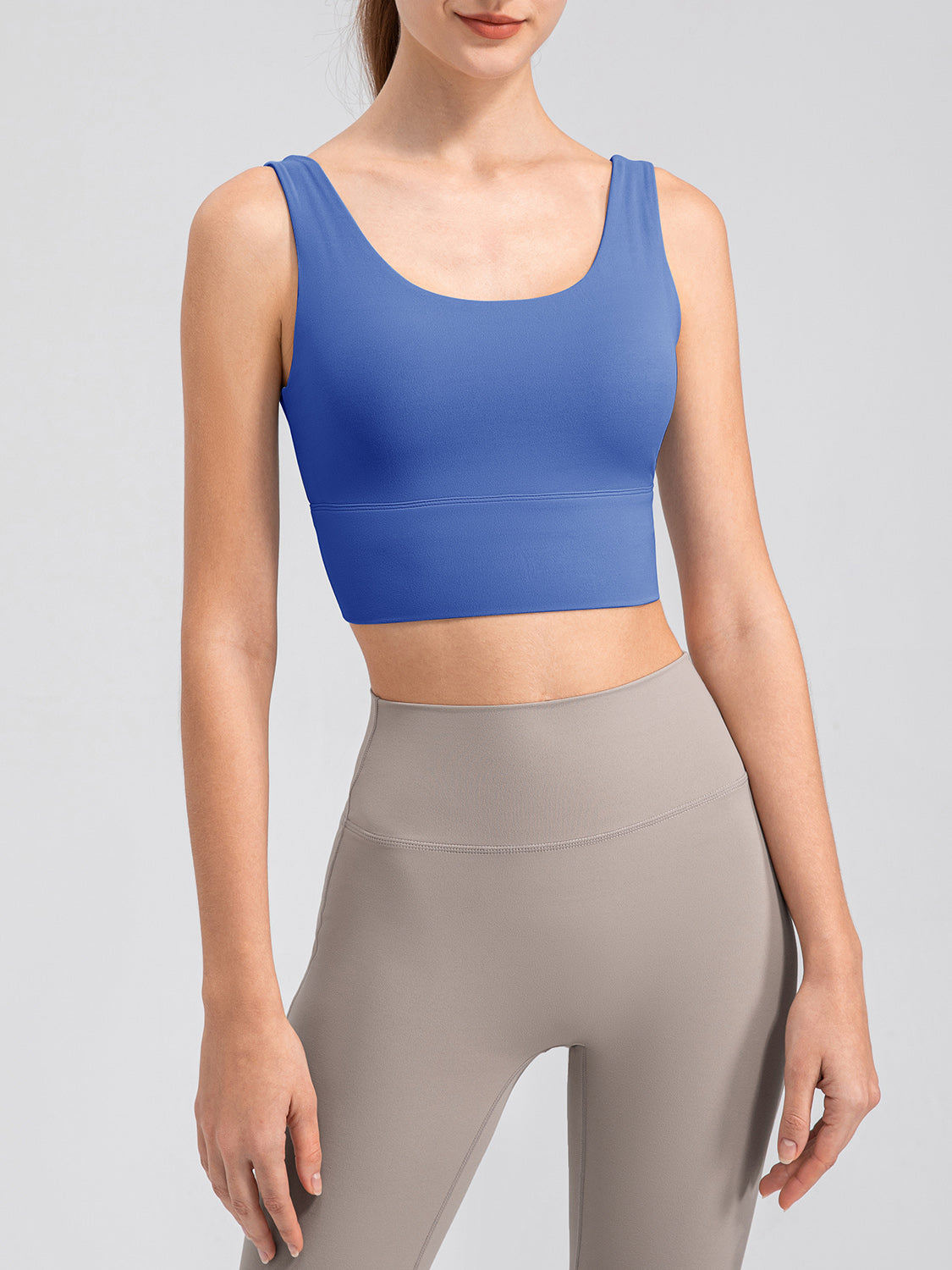 Blue scoop neck performance crop top with wide straps and a banded hem.