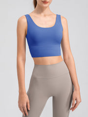 Blue scoop neck performance crop top with wide straps and a banded hem.