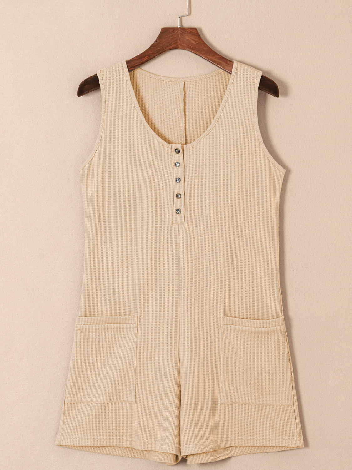 Camel waffle knit button-down romper with pockets and a scoop neck.