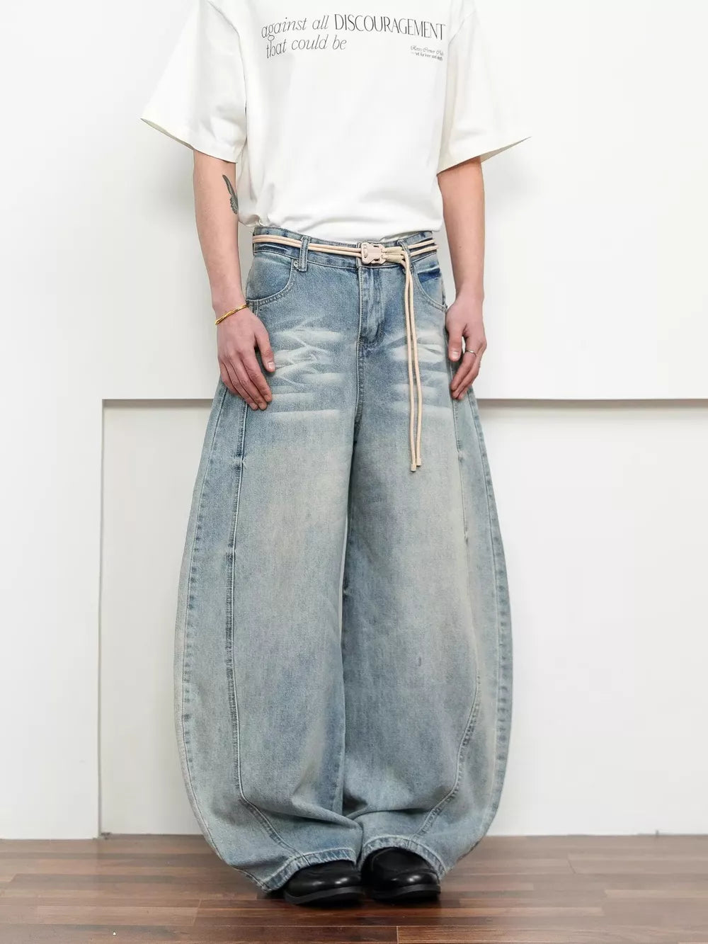 Belted wide leg jeans in light blue denim with a balloon silhouette and rope belt.
