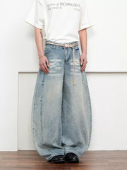 Belted wide leg jeans in light blue denim with a balloon silhouette and rope belt.