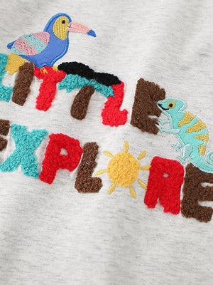 Toddler t-shirt with chenille letters spelling "LITTLE EXPLORE" featuring embroidered bird and chameleon.