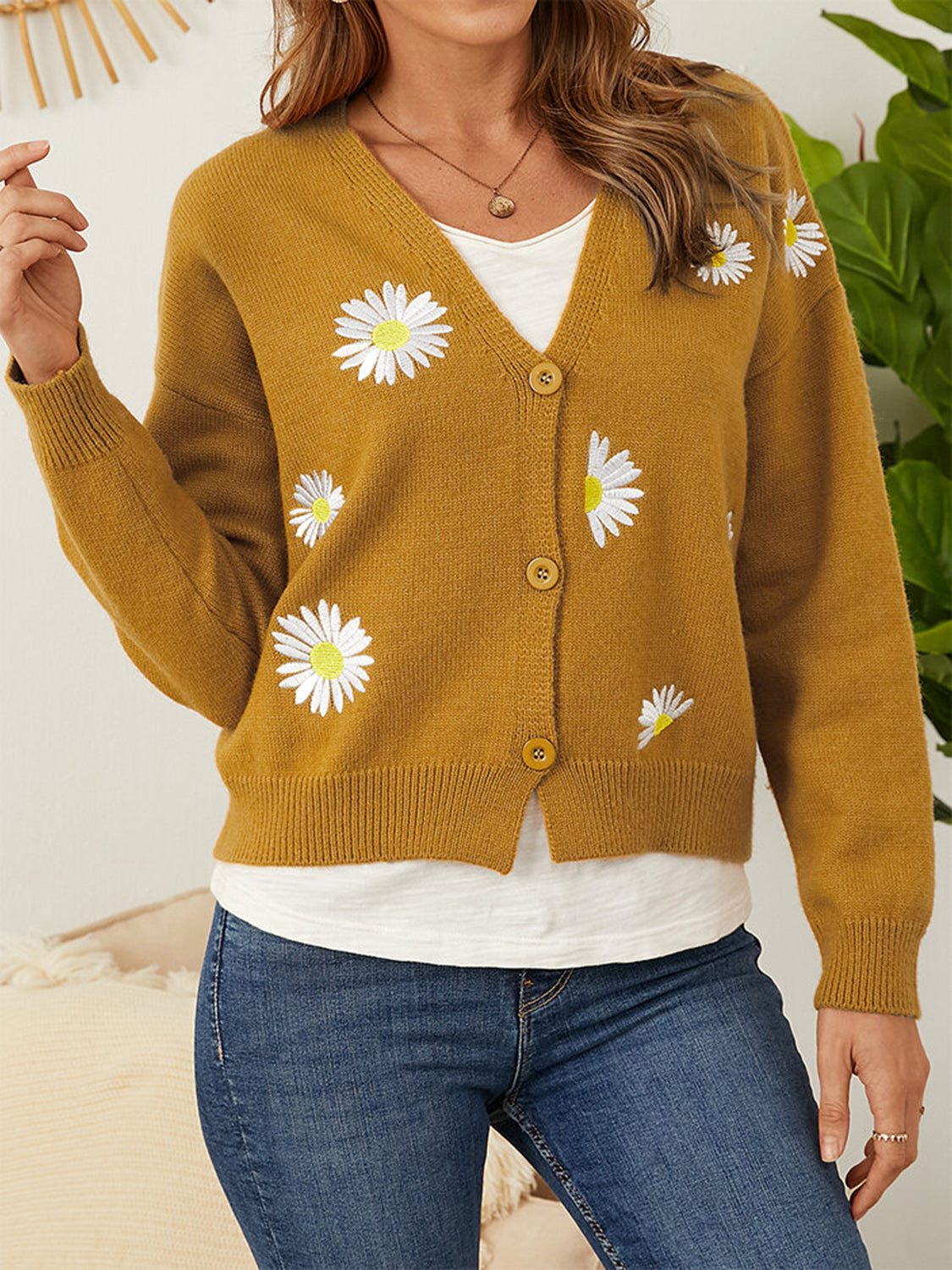 Mustard V-neck cardigan with daisy embroidery and button front.