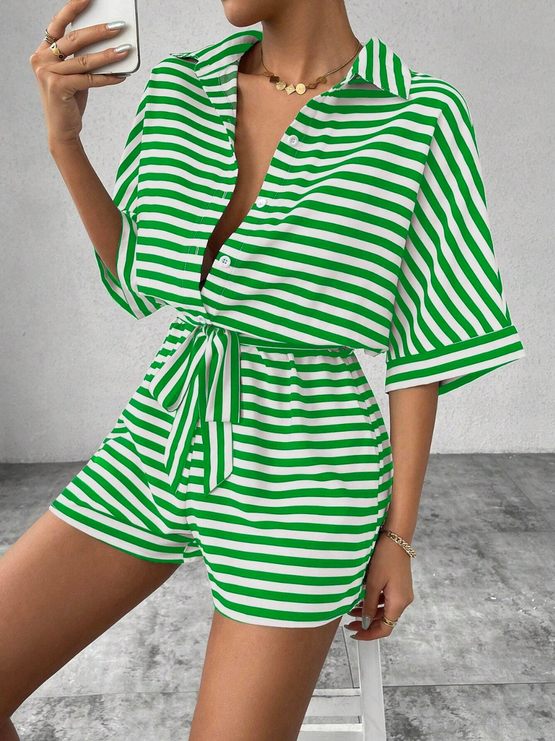 Green and white striped shirt romper with self-tie belt and button front.