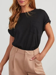 Black linen boxy tee with patch pocket and cuffed sleeves, worn with tan trousers.