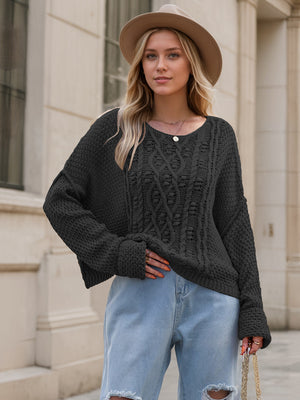 Black cable knit cocoon sweater with textured acrylic knit and a relaxed fit.