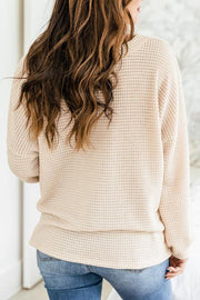 Waffle knit henley pullover in cream, showing the textured back and relaxed fit.