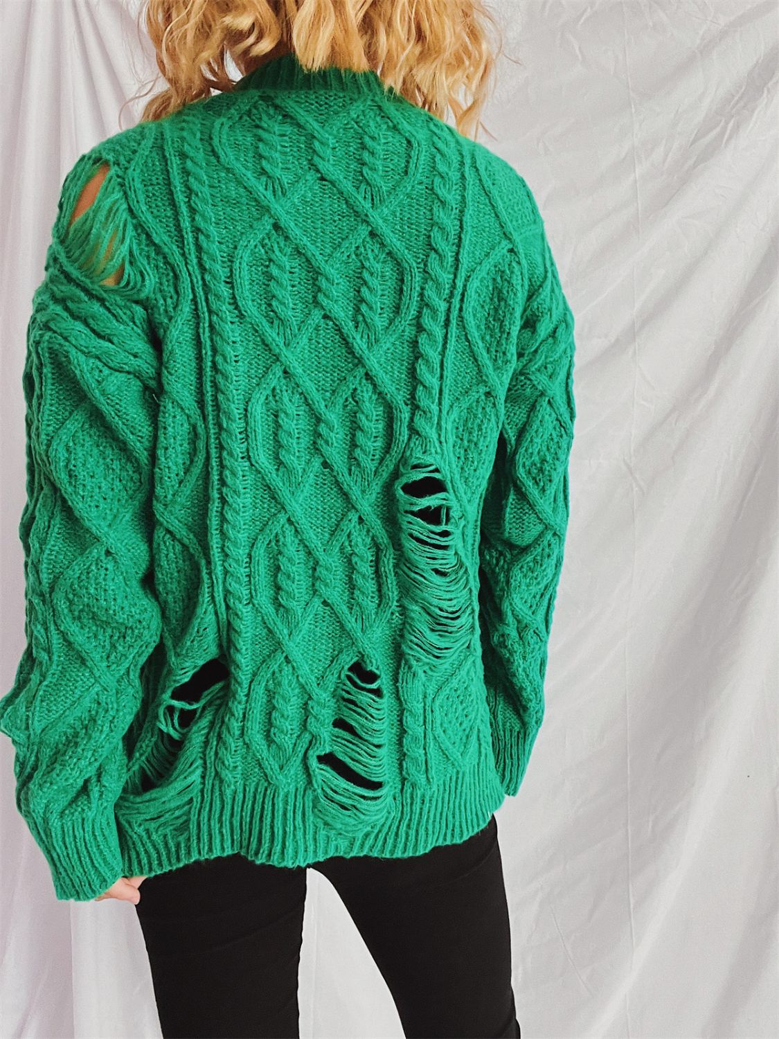 Green distressed cable knit sweater with ripped details.