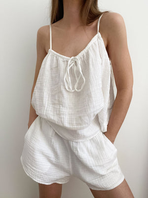 White cotton cami and shorts pajama set with tie-front cami and elastic waist shorts.