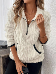 White sherpa half zip sweatshirt with chevron texture and black trim pockets.