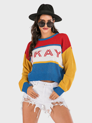 Colorblock knit sweater with "Okay" graphic in red and white, crew neck, long sleeves, and blue trim.