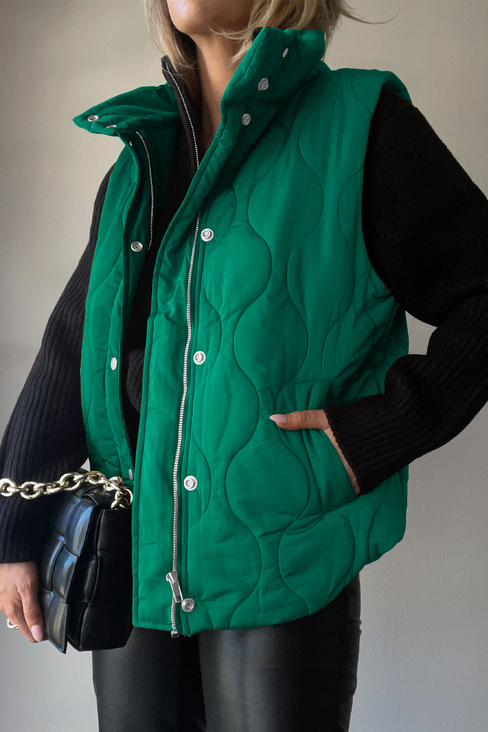 Green quilted stand-collar utility gilet with snap closures and pockets.
