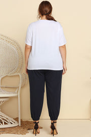 White t-shirt and navy jogger pants with cinched ankles, part of a lounge set.
