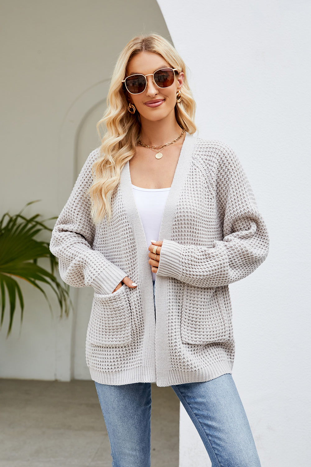Light gray waffle knit raglan pocket cardigan with open front and ribbed cuffs.