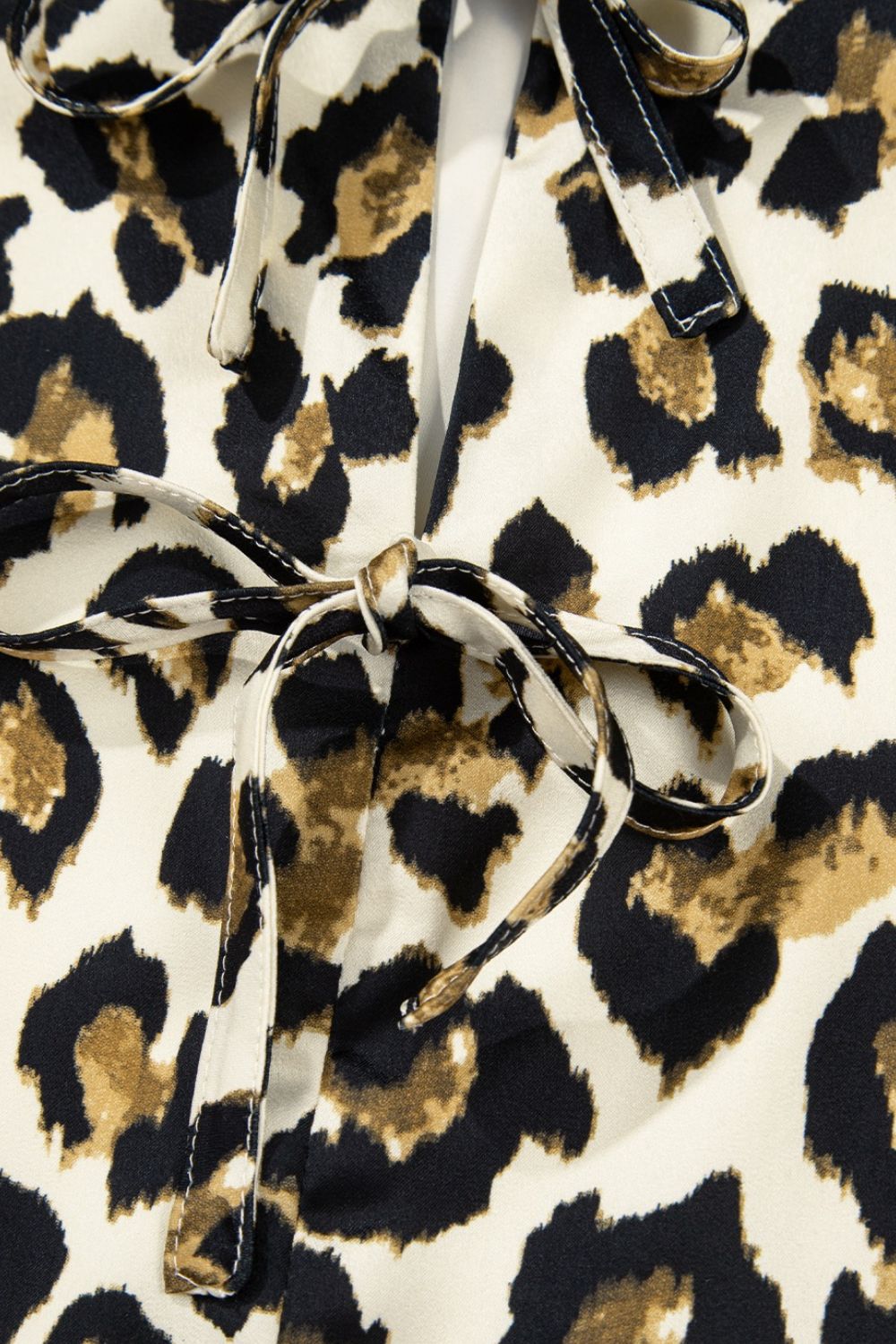 Leopard print blouse with tie-neck detail and peplum cut.