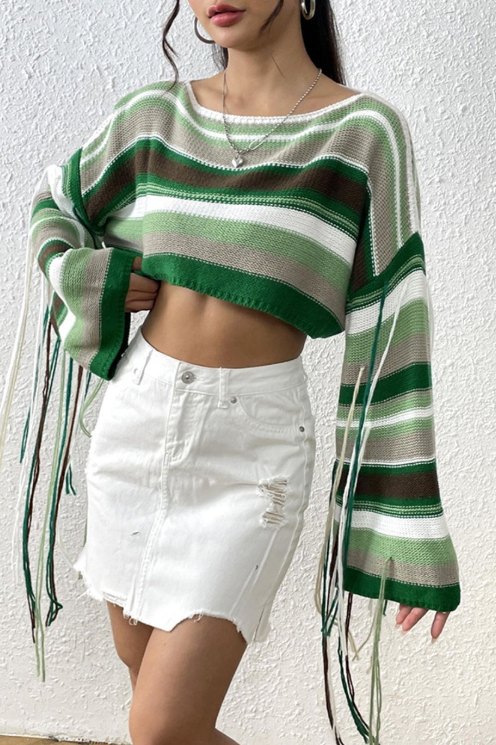 Cropped knit sweater with multicolor stripes and fringe details.