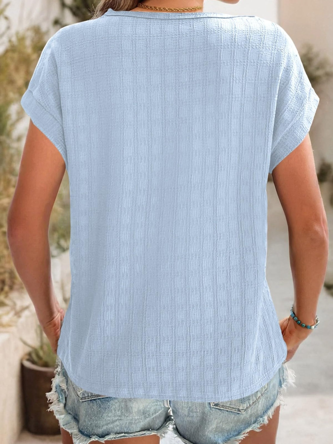 Light blue woven texture cap-sleeve top with a relaxed fit.