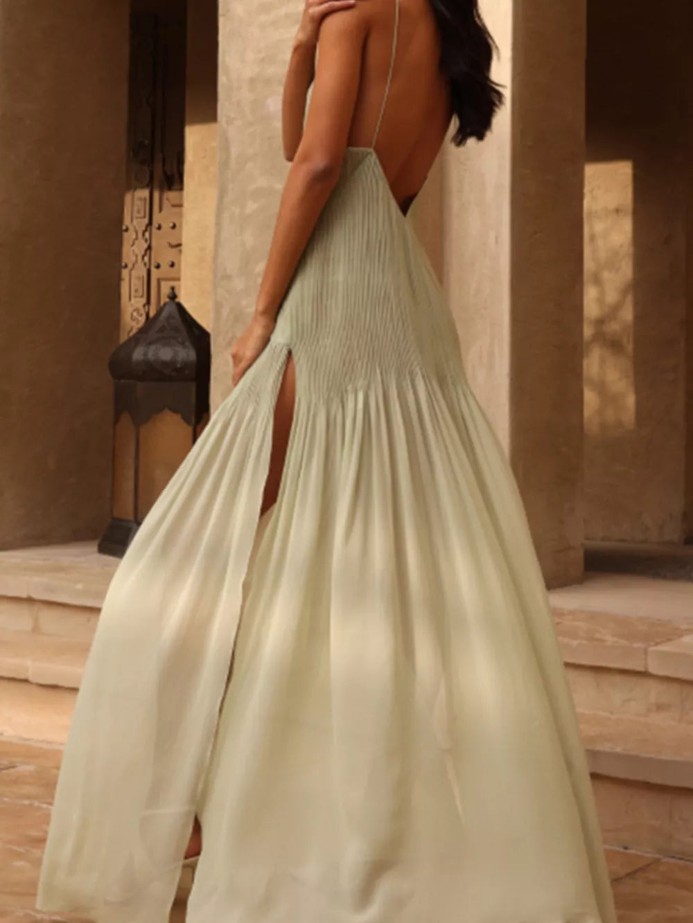 Sheer pleated maxi cami dress in light green with a high slit and open back.