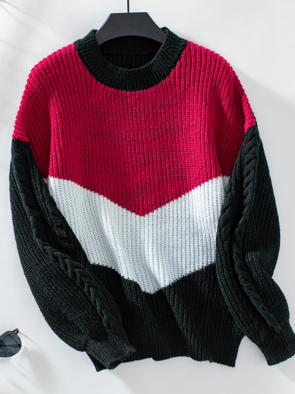 Chevron colorblock cable knit sweater in red, white, and black with cable knit sleeves.