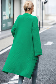 Longline green acrylic knit cardigan with pockets and side slits.