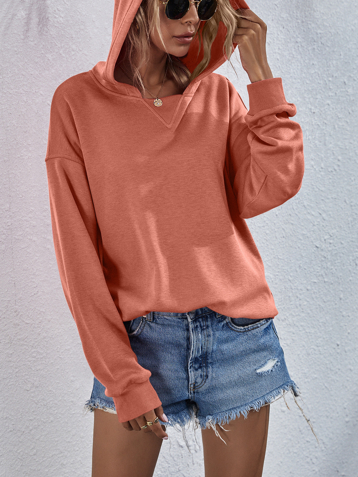 Boxy hooded sweatshirt in Tangerine with split neckline and cuffed sleeves.