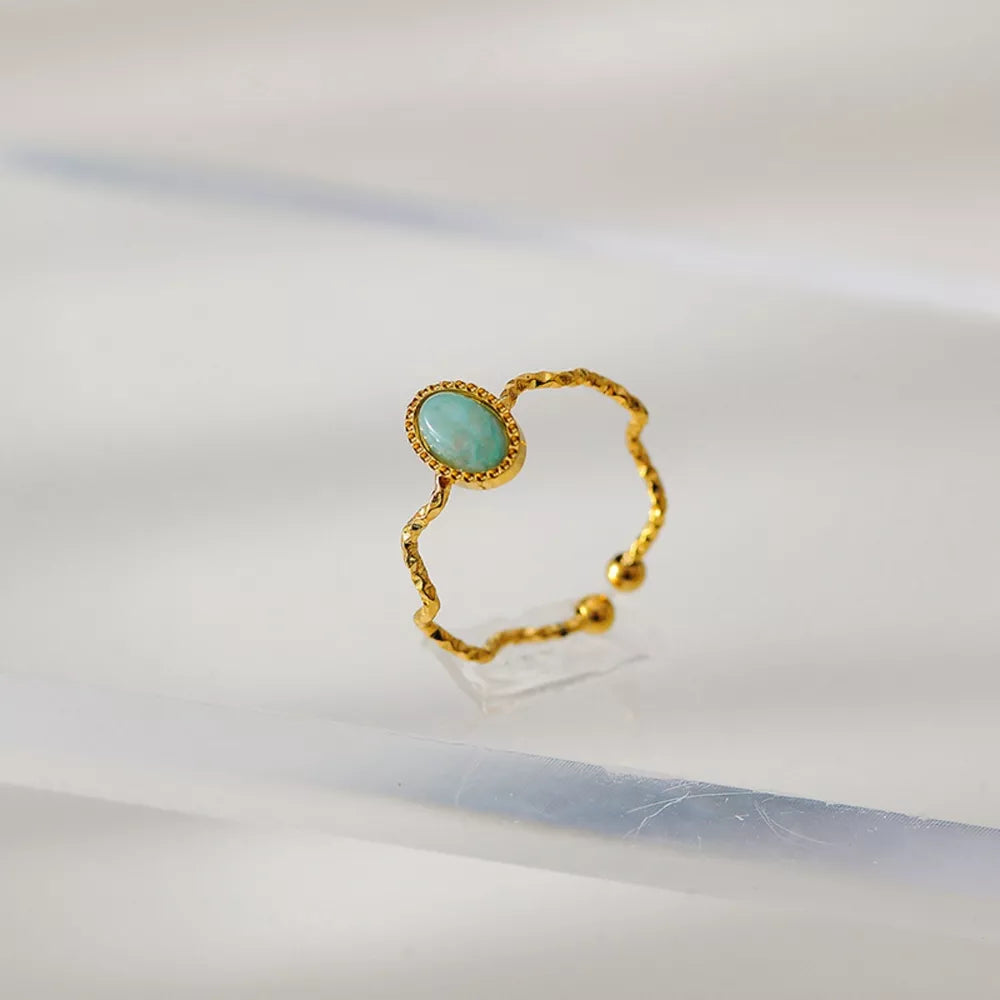 Wavy gold-plated ring with oval blue natural stone, delicate adjustable style.