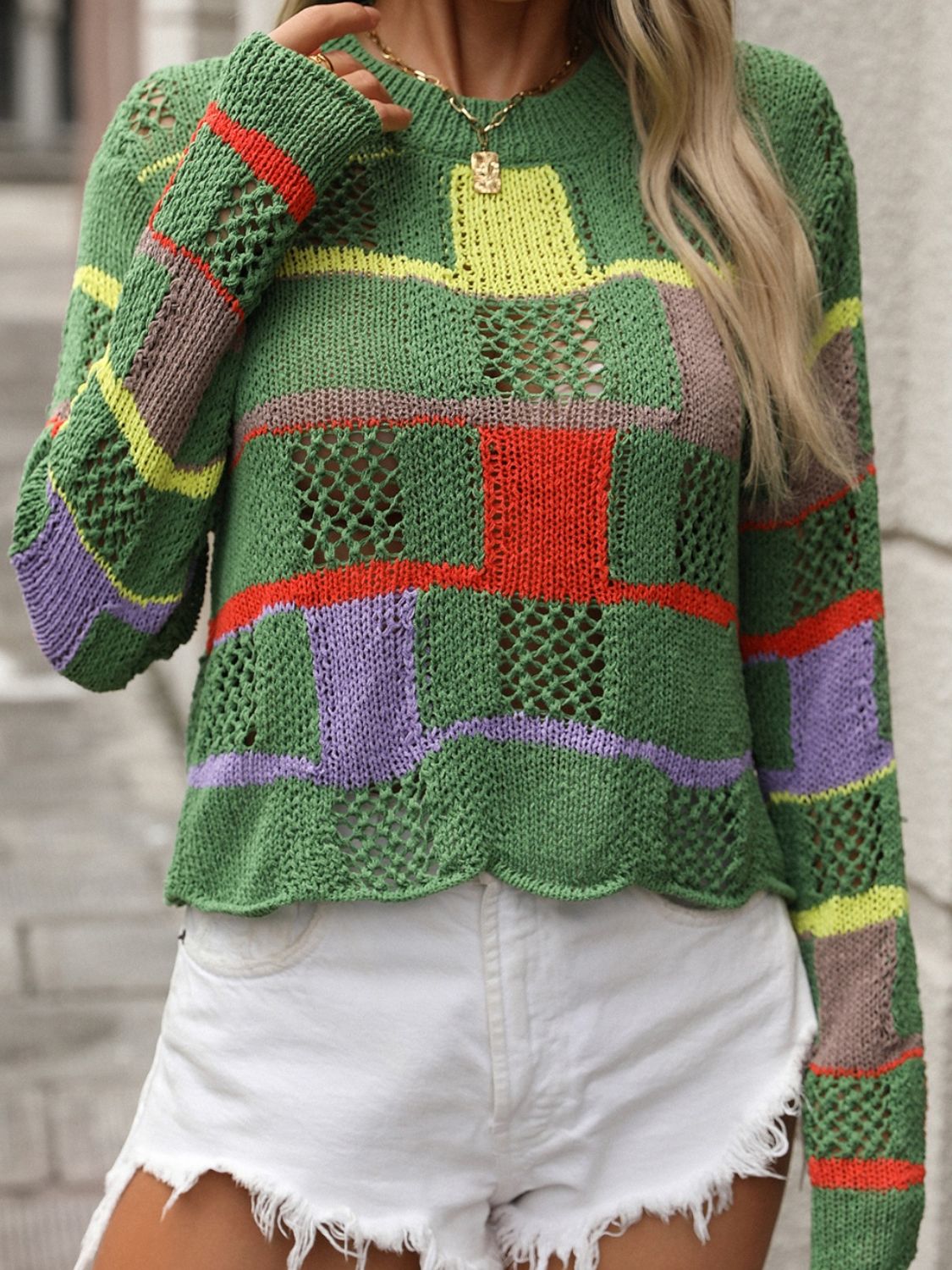 Green openwork knit sweater with colorful patchwork blocks and stripes, long sleeves, crew neck.