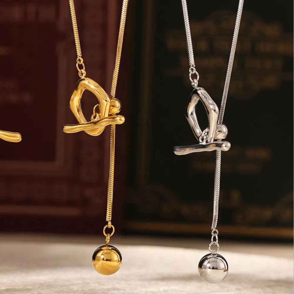 Gold and silver lariat necklaces with a gymnast charm and ball drop