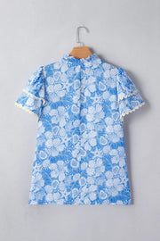 Blue floral print polyester blouse with frill neckline and scalloped sleeves.